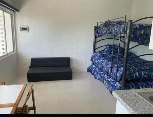 een kamer met 2 stapelbedden en een bank bij Loft 202 in Acapulco