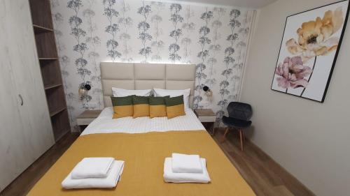 a bedroom with a large bed with two towels on it at DeMar Apart Sun in Kulʼparkuv