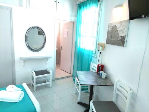 a room with a bed and a table and a mirror at Seatincenter Rooms in Mýkonos City