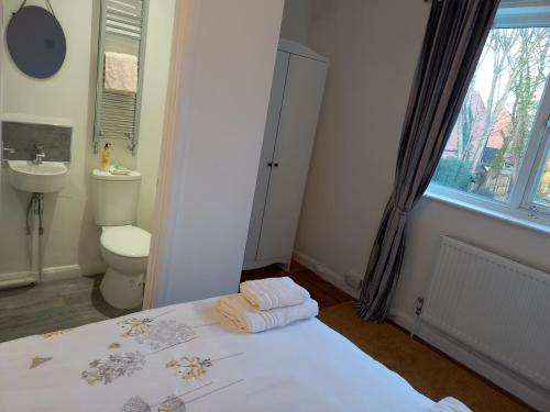 a bathroom with a bed and a toilet and a window at Charming 4-Bed Victorian House in Retford in Retford