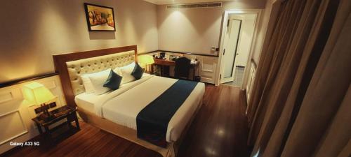 a bedroom with a large bed in a room at Nambiar Club Bellezea in Bengaluru