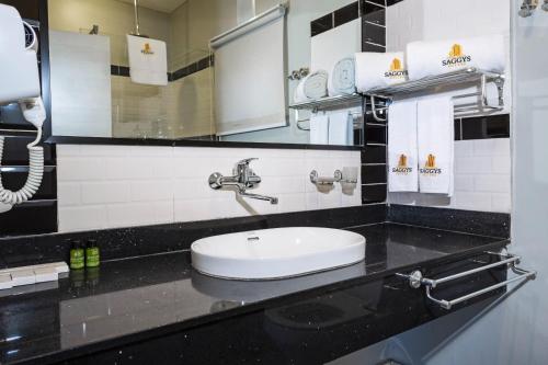 a bathroom with a sink and a mirror at Saggys Suites Hotel & Spa in Nairobi