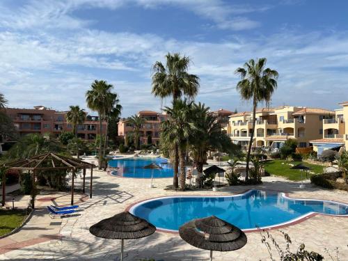 a view of the pool at a resort with palm trees at Tropical Paradise in Harbour Paphos, Central & Close to Beach in Paphos