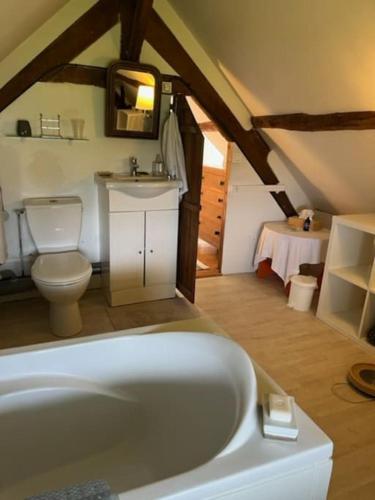 une salle de bain avec une baignoire, des toilettes et un lavabo dans l'établissement Jolie longère normande pres d'Honfleur et de Deauville, à Les Authieux-sur-Calonne