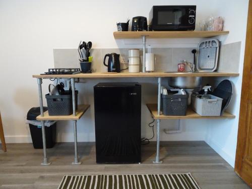 a black refrigerator sitting under a table in a room at Modern Barn Conversion in Brackley