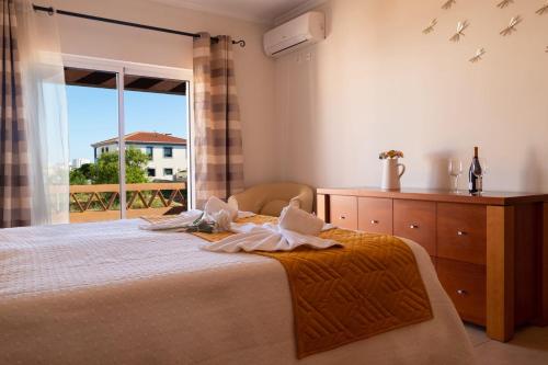 a bedroom with a bed and a large window at Casa Moreira in Lagos