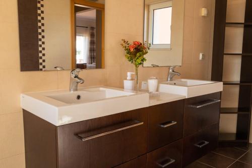 a bathroom with two sinks and a mirror at Casa Moreira in Lagos