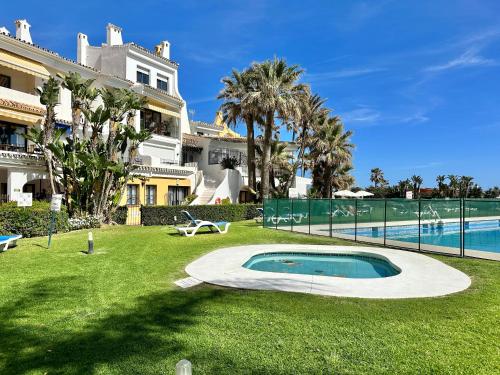 un cortile con piscina e una casa di Cabopino Port - EaW Homes a Marbella