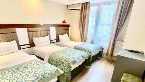 Cette chambre comprend 2 lits et une fenêtre. dans l'établissement LARA HOTEL, à Istanbul