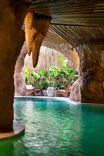 a swimming pool in a resort with a rock wall at KunKin Garden Aparthotel in Ho Chi Minh City