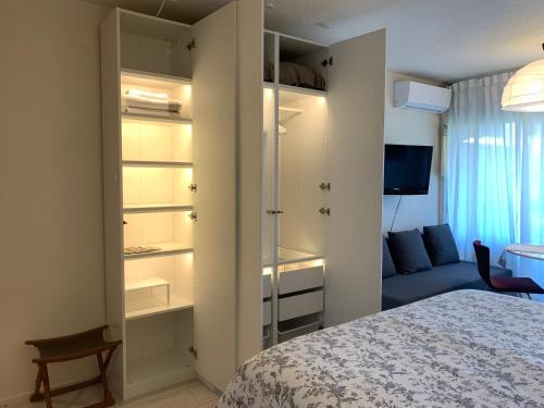 um quarto com uma cama e um quarto com uma televisão em Studio centre Saint Tropez parking piscine wifi vue mer em Saint-Tropez