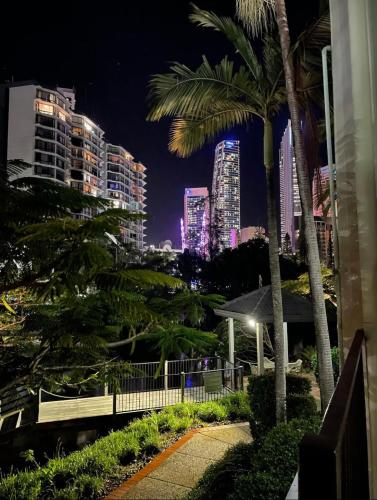 a city skyline at night with palm trees and buildings at Paradise Island Resort Surfers Paradise - Garden Suite in Gold Coast