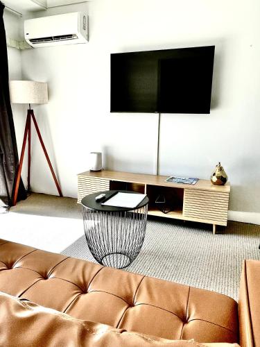 a living room with a couch and a flat screen tv at Paradise Island Resort Surfers Paradise - Garden Suite in Gold Coast