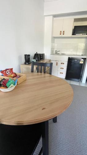 a kitchen with a wooden table in a kitchen at Paradise Island Resort Surfers Paradise - Garden Suite in Gold Coast