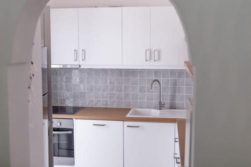 a kitchen with white cabinets and a sink at The View in Megalochori
