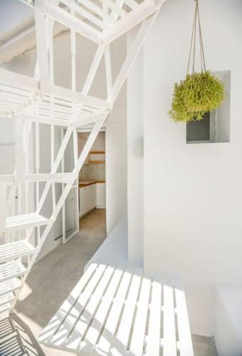 a white staircase in a white room with a potted plant at The View in Megalochori