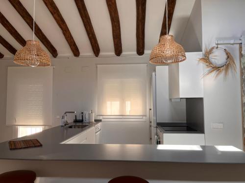 a kitchen with white cabinets and two lights at 18 Torres Estébanes in Zaragoza