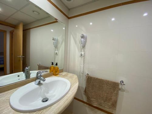 a bathroom with a sink and a shower and a mirror at Joan XXIII Apartment in Tarragona