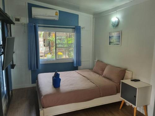 a small bedroom with a bed with a window at Rayonghouse Resort in Rayong