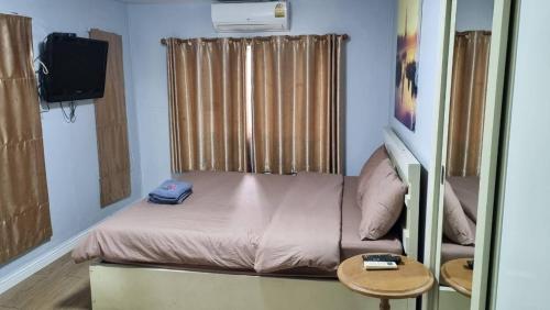 a small bed in a room with a small table at Rayonghouse Resort in Rayong