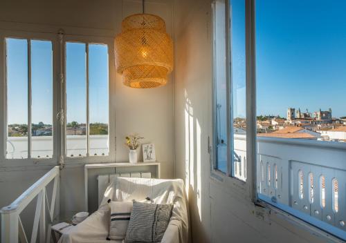 Cette chambre dispose d'une chaise et d'une fenêtre avec vue. dans l'établissement LE LANTERNON, à Saint-Martin-de-Ré