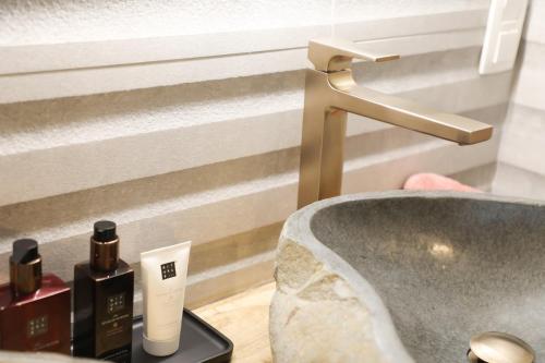 a bathroom with a sink and a faucet at Maison La Belle Cosy 2-bedroom house with jacuzzi & airco in Zoutleeuw