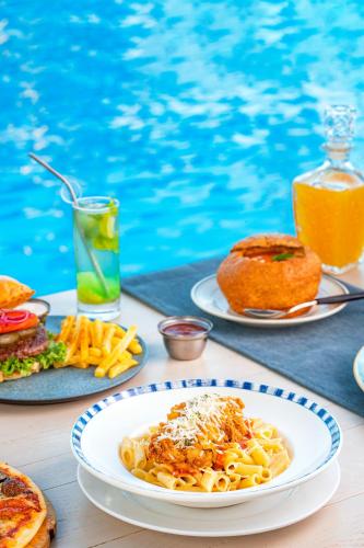 een tafel met borden pasta en brood en een drankje bij Selena Bay Resort & Beach Club in Hurghada