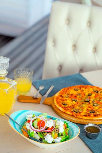 een tafel met een bord eten en een pizza bij Selena Bay Resort & Beach Club in Hurghada