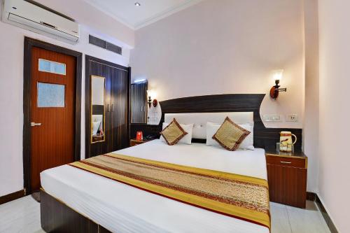 a bedroom with a large bed in a room at Merit Hotel in Tājganj