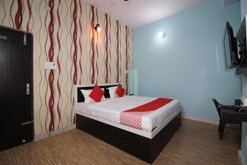 a bedroom with a bed with red pillows on it at Super Capital O Hotel Paradise Residency in Rāmnagar