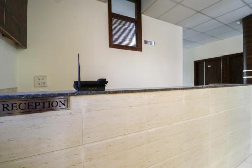 un bancone della reception in una stanza con un cartello che legge la ricezione di OYO Hotel Rk Inn a Ludhiana