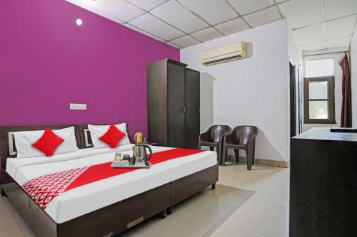 1 dormitorio con 1 cama con pared morada en Flagship Hotel Mahi, en Pānīpat