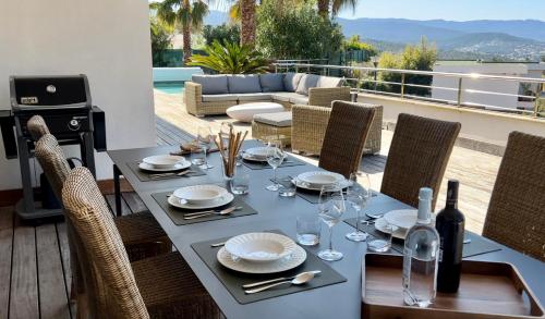 - une table avec des verres à vin et des assiettes sur la terrasse dans l'établissement le Pied à Terre 2 PORTICCIO, à Porticcio