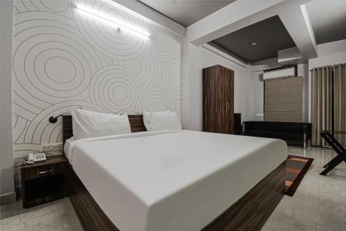 duże białe łóżko w pokoju ze ścianą w obiekcie Townhouse Vidya Vihar w mieście Dīgha