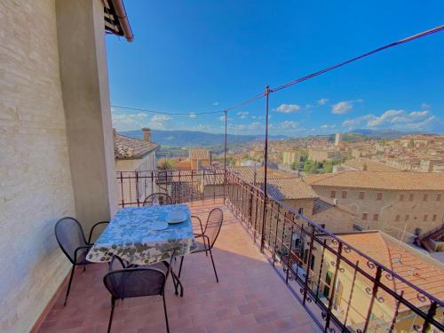 un patio con tavolo e sedie sul balcone. di CASE BALDELLI LA TERRAZZA a Perugia