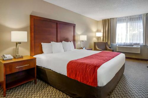 a hotel room with a large bed with a red blanket at Comfort Inn in Colville