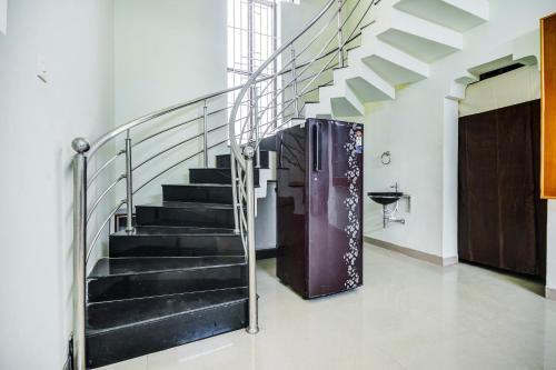 a staircase in a house with a metal railing at Aruthraa Residency in Podanūr