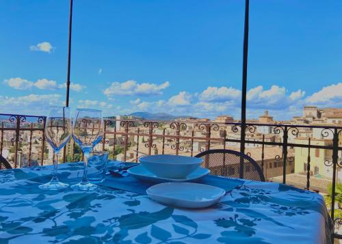 a blue table with glasses and plates on a balcony at CASE BALDELLI LA TERRAZZA in Perugia