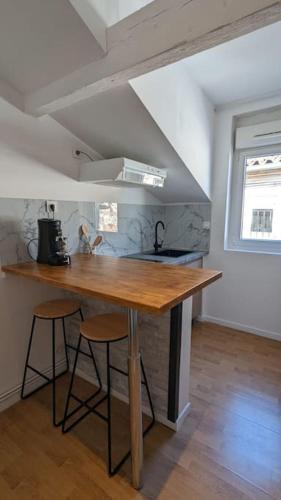 une cuisine avec un comptoir en bois dans une pièce dans l'établissement 2e Grand Studio Agen Hyper Centre - Clim - Jacobins, à Agen