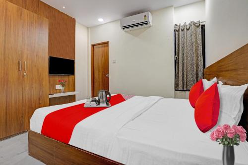 um quarto com uma cama grande e almofadas vermelhas em Flagship Hotel The Silver Nest em Nagpur