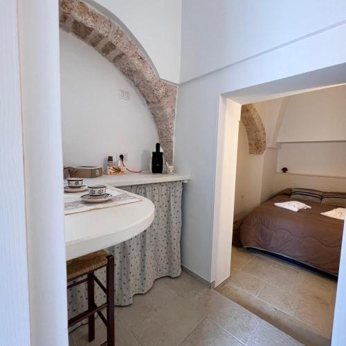 un bagno con lavandino e un letto in una camera di Trullo in Light ad Alberobello