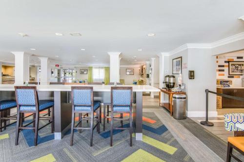 a large kitchen with a bar with blue chairs at MainStay Suites Columbus near Fort Benning in Columbus