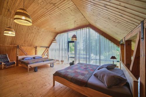a bedroom with a bed and a large window at Ugunu Dambji in Talsi