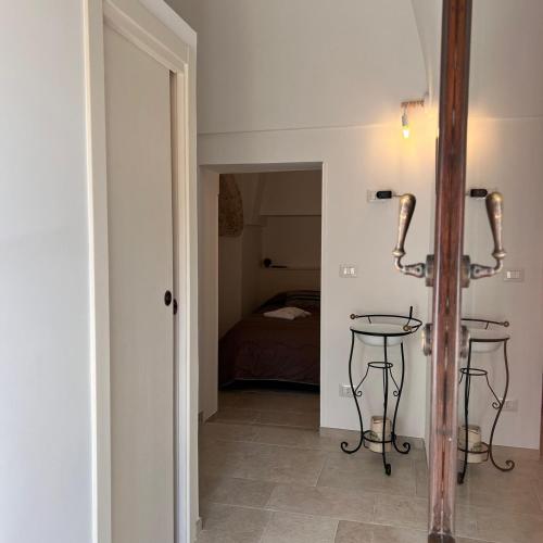 un corridoio con due tavoli e una camera con un letto di Trullo in Light ad Alberobello