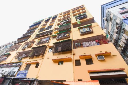 a tall yellow building with balconies on it at OYO Hotel Sonar Bangla Lodge in Kolkata