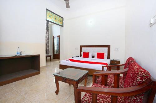 um quarto com uma cama, uma mesa e uma cadeira em OYO Nimantran Resort em Baddi
