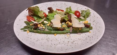 a white plate with a salad on a table at La Méridienne - Chambres d'hôtes in Venterol