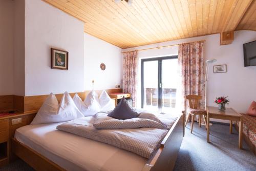 リフィアーノにあるPension Margrethの木製の天井のベッドルーム1室(大型ベッド1台付)