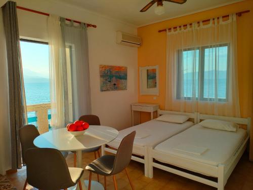 a bedroom with a bed and a table and chairs at Papas Rooms on the Seafront in Oreoí