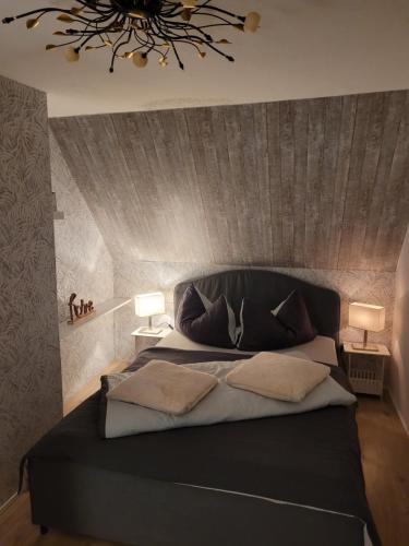 a bedroom with a large black bed with two lamps at Neues Schwalbennest 26 Haus in Büsum